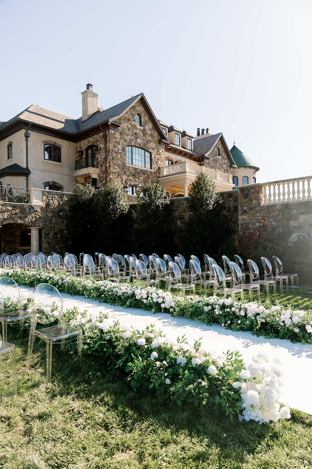 Outdoor ceremony with ghost chairs